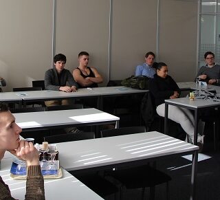 Bert Hinnen in de klas om voorlichting te geven over de waterschapsverkiezingen.
