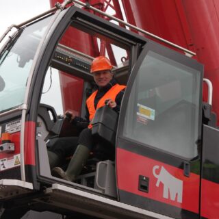 Hans de Jong van Water Natuurlijk plaatst een deel van de nieuwe brug bij de Vreugderijkerwaard.
