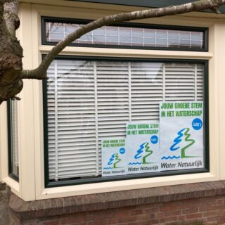 verkiezingsposters Water Natuurlijk achter het raam